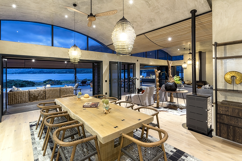 <p>LIVING AND DINING<br /> The open plan lounge and dining room has with wide glass doors and windows overlooking the Lagoon and is<br /> equipped with ceiling fans, underfloor heating, a wood-burning fireplace and eco-friendly pellet stoves.<br /> The rooms are decorated with sympathetically and sustainably sourced stylish unique African artefacts with<br /> explanations of their provenance provided and with pictures by local up-and-coming artists.<br /> – Main lounge open plan leads onto kitchen and large dining area<br /> – Dining area for 10 guest<br /> – Free-flowing entertainment and living areas<br /> – Wood combustion and eco fireplaces in living the room provide a gracious retreat on chilly evenings.<br /> – Inside and outside living areas are equipped with a state-of-the-art eight speakers four-zoned SONOS<br /> wireless audio system to play the music of your choice effortlessly from your phone or tablet / iPad.<br /> – Big glass doors and windows allow natural light flood into the house<br /> – Celling fans, underfloor heating in main and dining areas<br /> – Spacious entertainment areas, outdoor living and private heated rim-flow pool<br /> KITCHEN<br /> – The House is equipped with a fully interactive, designer kitchen with a separate scullery room and<br /> laundry room.<br /> – Fully equipped Interactive designer kitchen with the latest kitchen equipment<br /> – A small decorative herb garden providing fresh ingredients for the kitchen is available for guest’s use</p>